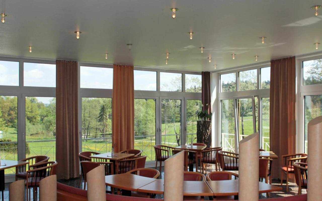 Bild Fensterfront in der Cafeterie mit Sicht auf den Klinikpark, sowie Fischweiher