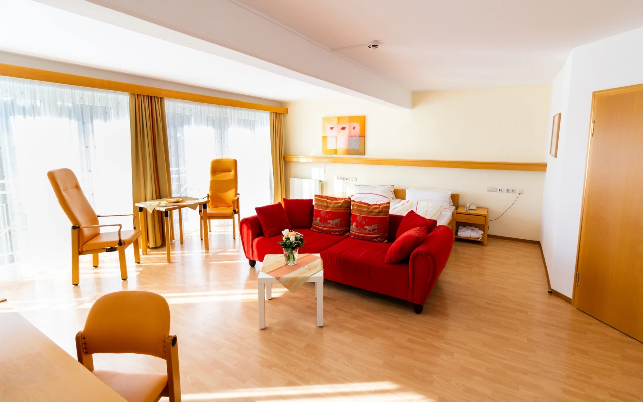 Bild Komfortzimmer Wohnbereich mit Sofa und 2 Stühlen mit Tisch