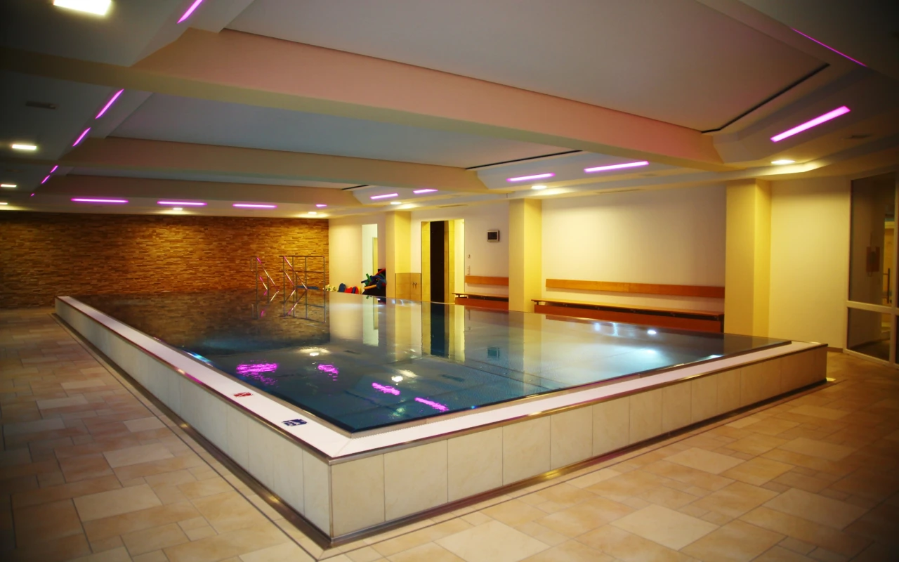 Bild Modernes Bewegungsbecken der Klinik Prof. Schedel mit angenehmem Stimmungslicht für therapeutische Wasseranwendungen, Rehabilitation und gelenkschonendes Training in entspannter Atmosphäre.