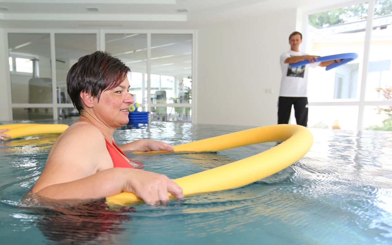 Bild Wassergymnastik Patientin wird angeleitet vom Sporttherapeuten